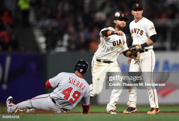 Brandon Crawford of the San Francisco Giants completes a double-play over the top of Moises Sierra of the Washington Nationals in the top of the six...