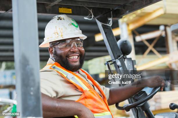 afrikanisch-amerikanischer mann fahren gabelstapler im holzlager - gabelstapler amerika stock-fotos und bilder