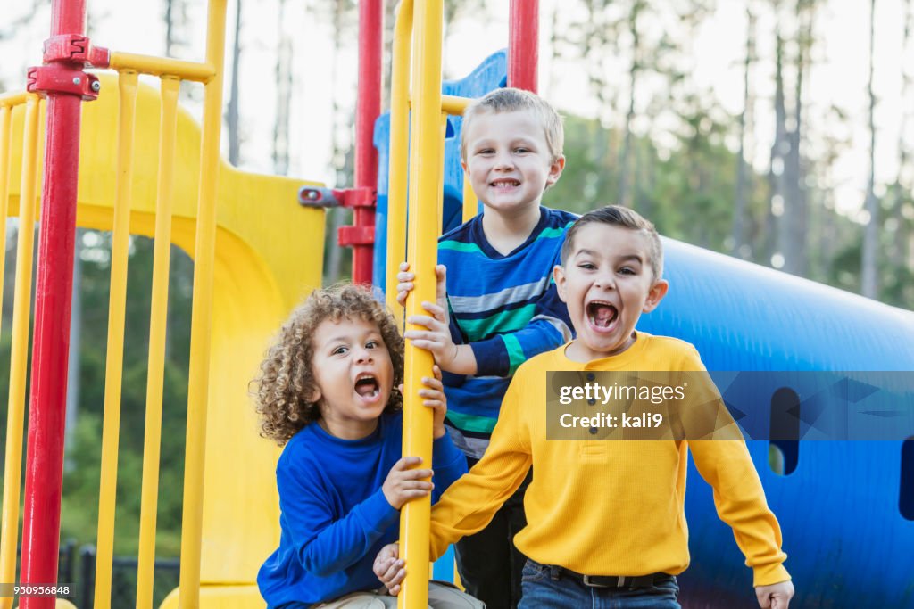 Three multi-ethnic boys playing on playground