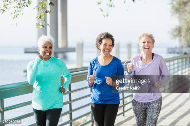 drei reife und ältere frauen, die auf wasser laufen - power walking stock-fotos und bilder