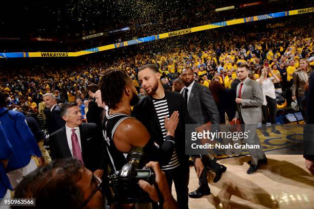 Patty Mills of the San Antonio Spurs and Stephen Curry of the Golden State Warriors exchange a hug following Game Five of Round One of the 2018 NBA...
