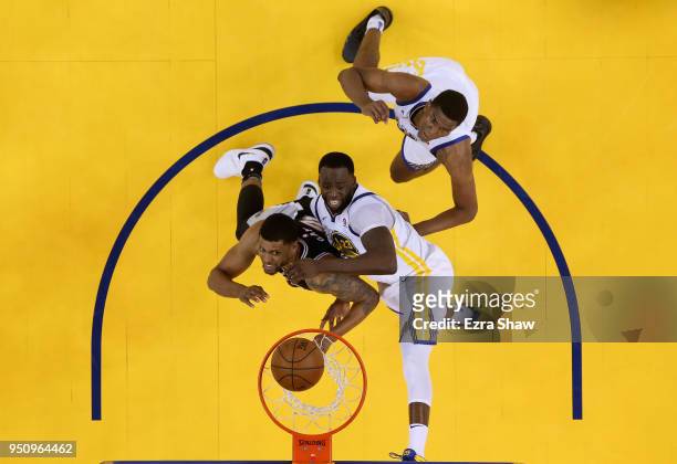 Draymond Green and Kevon Looney of the Golden State Warriors go up for a rebound against Rudy Gay of the San Antonio Spurs during Game Five of Round...