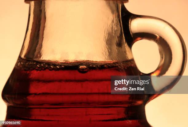 backlit close-up of maple syrup in a bottle with handle - maple syrup stock pictures, royalty-free photos & images
