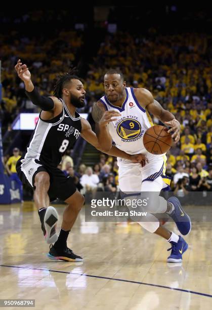 Andre Iguodala of the Golden State Warriors drives on Patty Mills of the San Antonio Spurs during Game Five of Round One of the 2018 NBA Playoffs at...