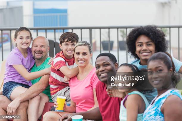 two families sitting together on a pool deck - adirondack chair closeup stock pictures, royalty-free photos & images