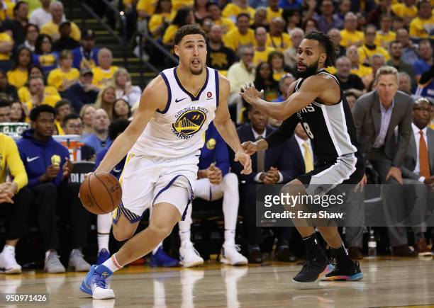 Klay Thompson of the Golden State Warriors drives on Patty Mills of the San Antonio Spurs during Game Five of Round One of the 2018 NBA Playoffs at...