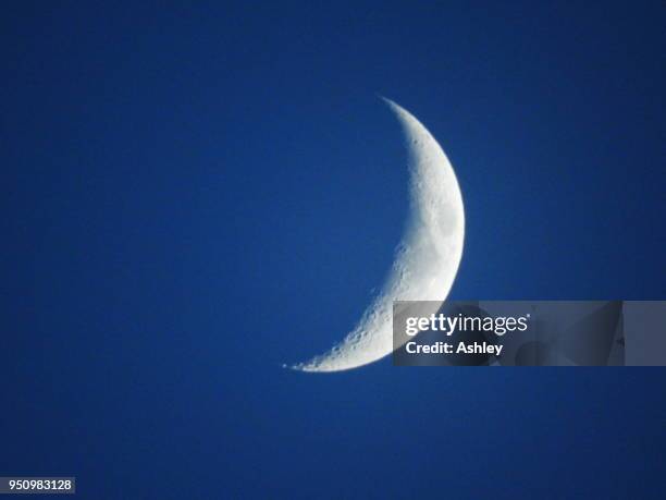 close up detail of a crescent moon against a blue sky - moneda de veinticinco céntimos fotografías e imágenes de stock