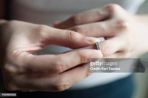 a woman wears her wedding ring - taking off wedding ring stock pictures, royalty-free photos & images