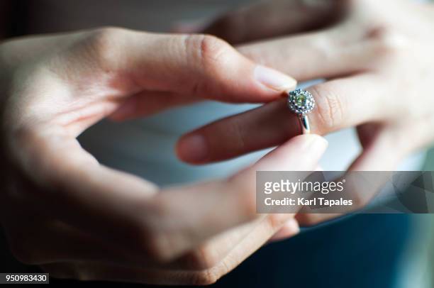 a woman wears her engagement ring - engagement ring foto e immagini stock