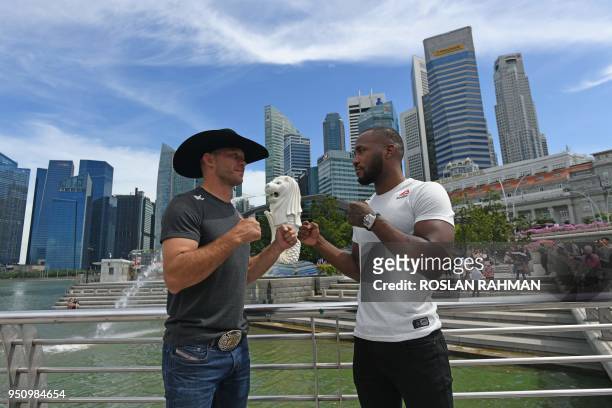 Mixed martial arts fighters Donald 'Cowboy' Cerrone of the US and Leon 'Rocky' Edwards of Britain pose for photos against the skyline at the Merlion...