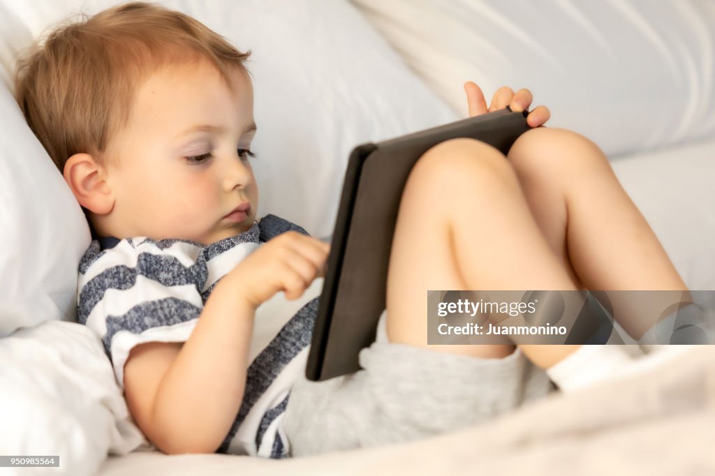 Playing with his electronic tablet