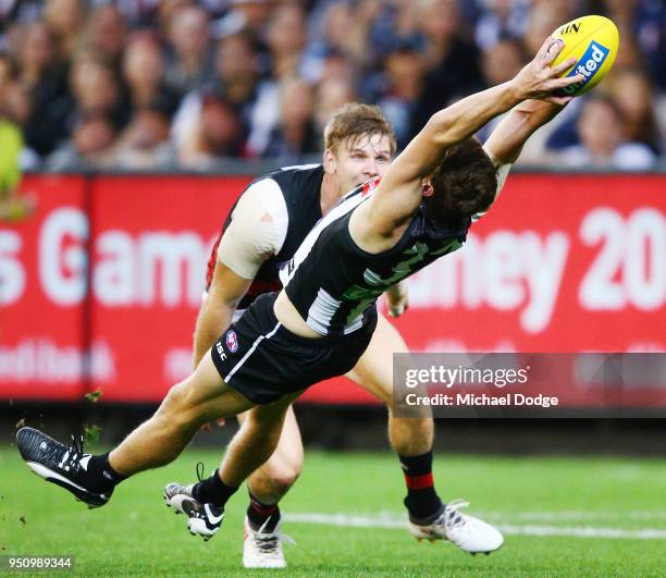 Will Hoskin-Elliott of the Magpies takes a diving mark against Michael Hurley of the Bombers during the round five AFL match between the Collingwood...