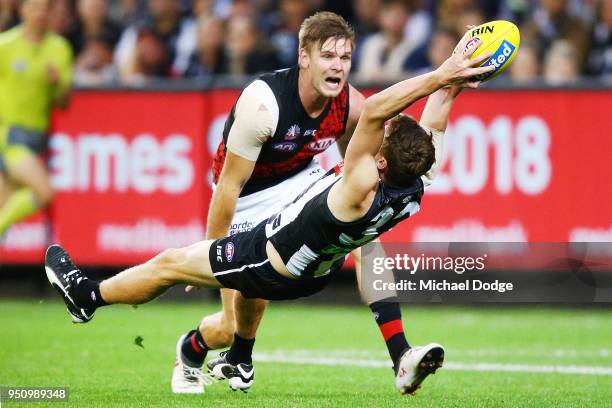 Will Hoskin-Elliott of the Magpies takes a diving mark against Michael Hurley of the Bombers during the round five AFL match between the Collingwood...