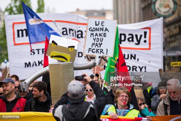 People hold banners during a demonstration attended from Amazon-Workers, trade union members and left activits under the motto 'Make Amazon Pay' in...