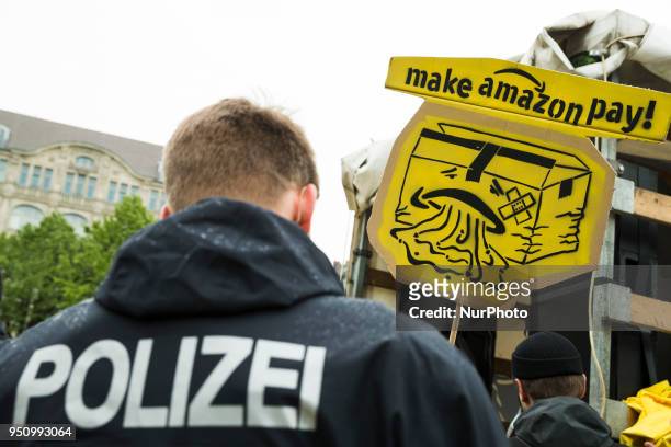 People hold banners during a demonstration attended from Amazon-Workers, trade union members and left activits under the motto 'Make Amazon Pay' in...