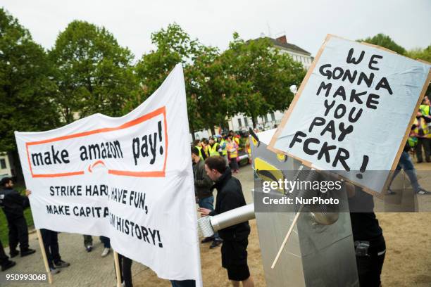 People hold banners during a demonstration attended from Amazon-Workers, trade union members and left activits under the motto 'Make Amazon Pay' in...