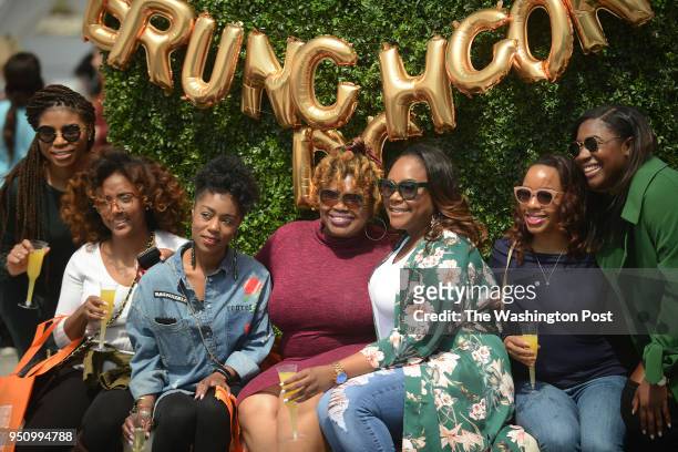 Brunch enthusiasts, with their mimosas in their hands, gather for a group picture while arriving at BrunchCon, a food and drink festival dedicated to...