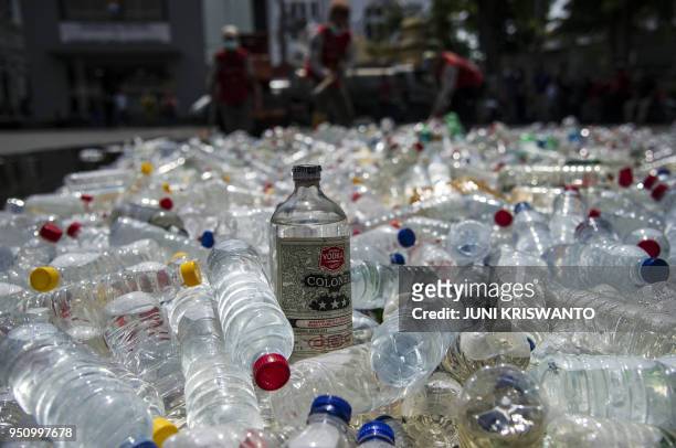 Bottles of bootleg alcohol are ready to be destroyed after a recent raid in Surabaya on April 25, 2018. - In total around 100 Indonesians are...