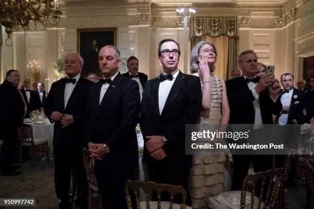 Treasury Secretary Steve Mnuchin stands with others before President Donald J. Trump and first lady Melania Trump host French President Emmanuel...