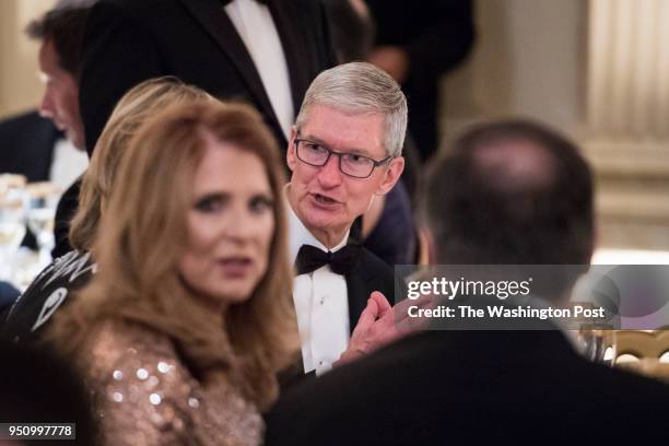 Apple CEO Tim Cook talks with others before President Donald J. Trump and first lady Melania Trump host French President Emmanuel Macron and his wife...