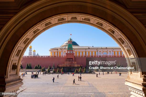 tourists walking around lenin mausoleum and kremlin palace on red square, moscow, russia - lenin memorial stock pictures, royalty-free photos & images