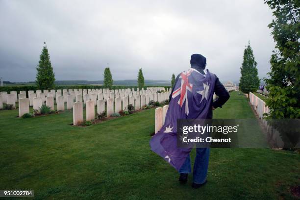 Man wrapped in Australian flags walks past graves at the Australian War Memorial after the ceremony of the Centenary of the Battle of...