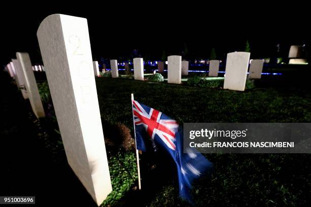 Photo taken on April 25, 2018 shows an Australian flag by the tomb of a soldier at the Australian military cemetery of Villers-Bretonneux, northern...