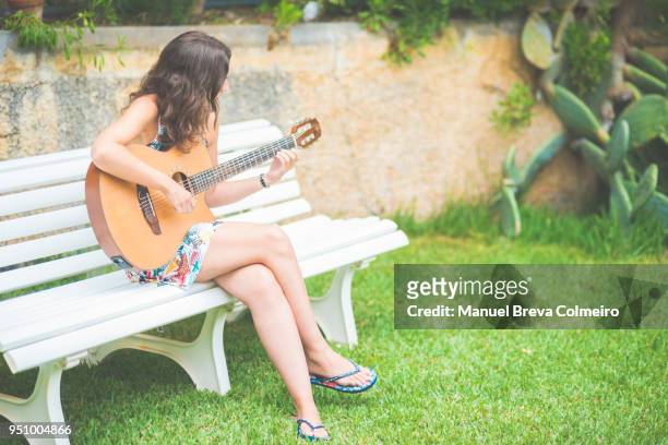 woman playing the guitar in the garden - guitar pick stock pictures, royalty-free photos & images