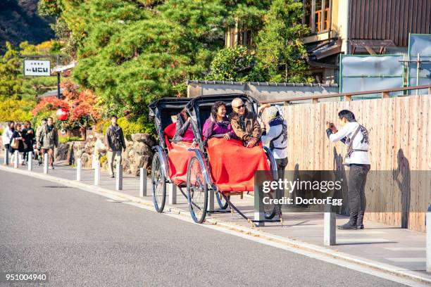 tourists on the japanese rickshaw at togetsukyo bridge, arahiyama, kyoto in autumn - 渡月橋 ストックフォトと画像