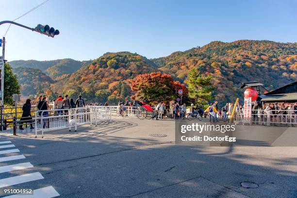 tourists enjoy maple trees sightseeing on the togetsukyo bridge in autumn - 渡月橋 ストックフォトと画像