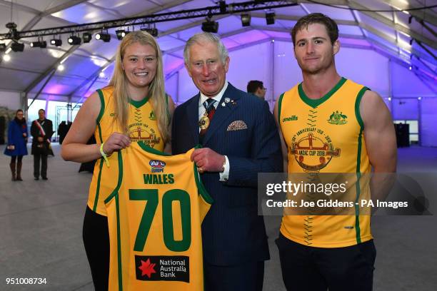 The Prince of Wales is presented with an Anzac Cup AFL jersey by Australian Spirit women's captain Priscilla Lodge and men's captain Edward Morgan...