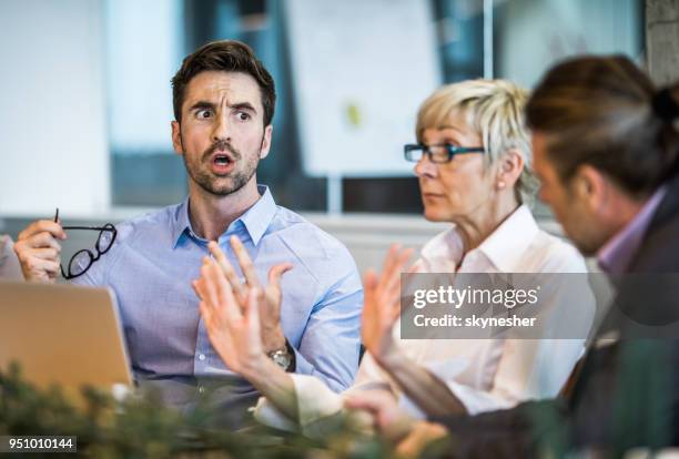 junger geschäftsmann mit seinem kollegen auf einem treffen im büro zu argumentieren. - body language at work stock-fotos und bilder
