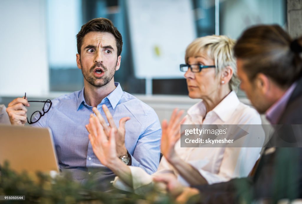 Jovem empresário discutindo com seu colega em uma reunião no escritório.