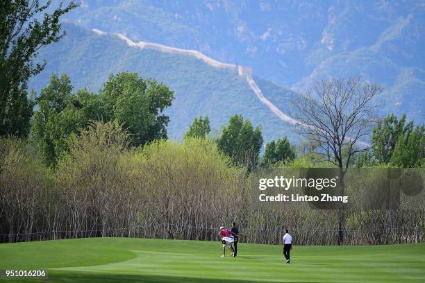 Li Haotong of China walks towards the 12 th fairway prior ahead of the 2018 Volvo China Open at Topwin Golf and Country Club on April 25, 2018 in...