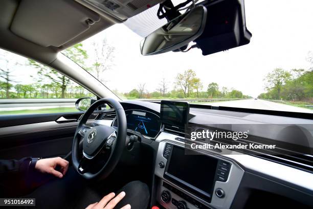 Test driver rests his hands as artificial intelligence takes over driving the car during tests of autonomous car abilities conducted by Continental...