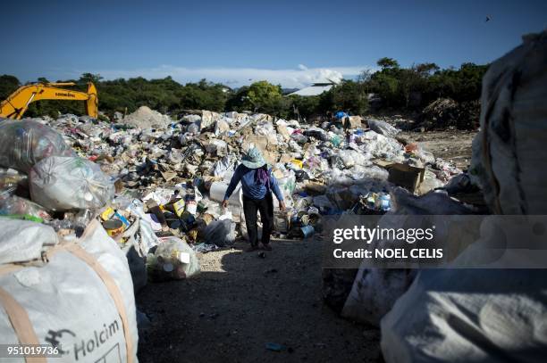 Gina Galan collects plastic bottles on the Boracay dumpsite called "materials recovery facility " in the Philippine island of Boracay on April 25,...