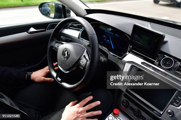 Test driver rests his hands as artificial intelligence takes over driving the car during tests of autonomous car abilities conducted by Continental...