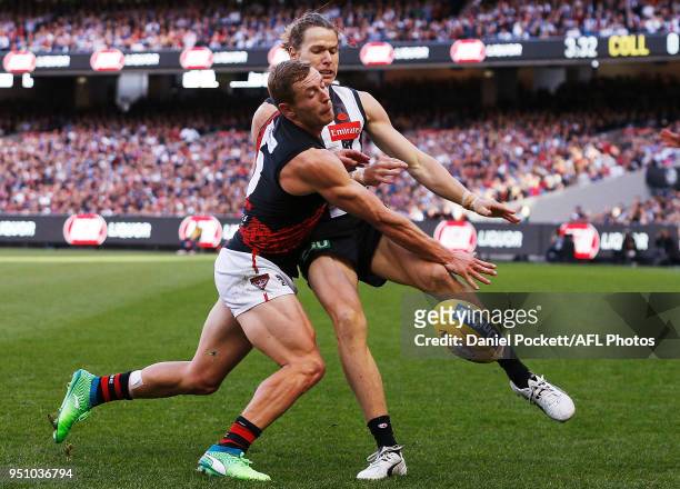 Devon Smith of the Bombers smothers Tom Langdon of the Magpies kick during the round five AFL match between the Collingwood Magpies and the Essendon...