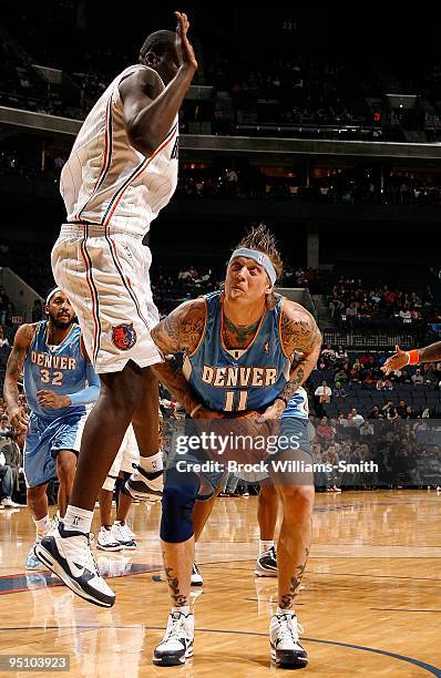 Chris Andersen of the Denver Nuggets moves the ball against DeSagana Diop of the Charlotte Bobcats during the game on December 8, 2009 at Time Warner...