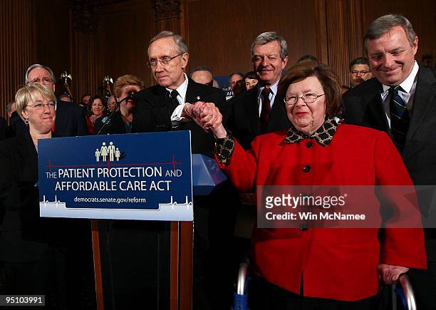 Senate Majority Leader Harry Reid shakes hands with Sen. Barbara Mikulski who cast the 60th vote in a final series of procedural votes on pending...