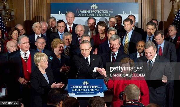 Senate Majority Leader Harry Reid shakes hands with Maryland Senator Barbara Mikulski alongside US Senate Democrats during a press conference after a...