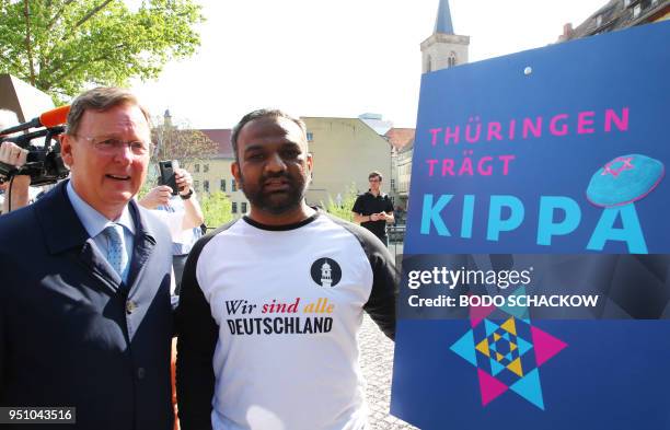 Thuringia's State Premier Bodo Ramelow and Mailk Mohamed Suleman from the Muslim Ahmadiyya community pose next to an ad for the "Thuringia wears...