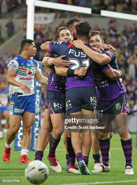 Ryley Jacks of the Melbourne Storm is congratulated by Billy Slater and his teammates after scoring a try during the round eight NRL match between...