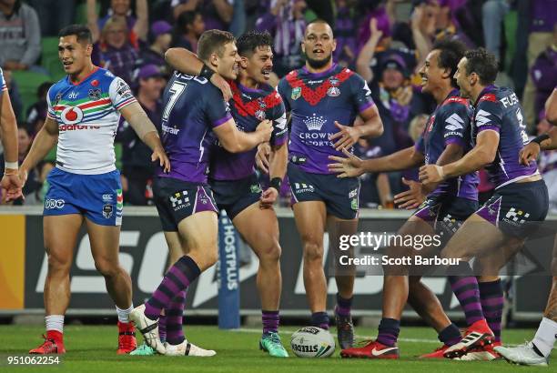 Ryley Jacks of the Melbourne Storm is congratulated by his Billy Slater of the Melbourne Storm and his teammates after scoring the first try during...