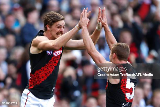 Joe Daniher of the Bombers celebrates a goal with Devon Smith of the Bombers during the 2018 AFL round five ANZAC Day match between the Collingwood...