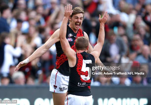 Joe Daniher of the Bombers celebrates a goal with Devon Smith of the Bombers during the 2018 AFL round five ANZAC Day match between the Collingwood...