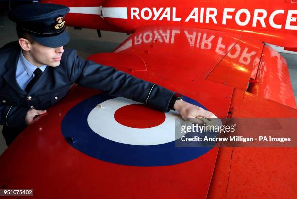 Flying officer Scott Bagshaw wipes the wing of the Red Arrows Hawk after it was maneuvered into a hanger next to Concorde where it will be on display...