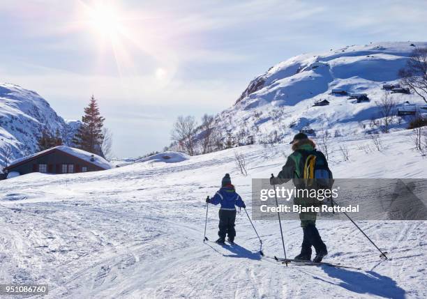 little girl cross-country skiing with grandparent - bjarte rettedal stock pictures, royalty-free photos & images