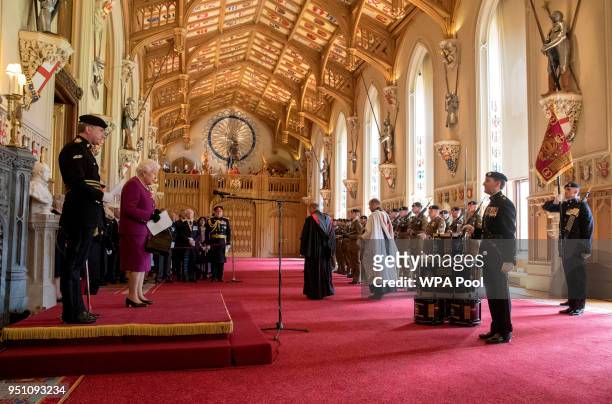 Queen Elizabeth II, Colonel-in-Chief of the Royal Tank Regiment, presents the regiment with their new standard in St George's Hall at Windsor Castle...