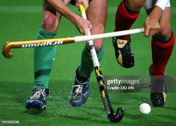 Player from England and player from Ireland vie for a ball during a Hockey World Cup Qualifier Pool A match, 12 April 2006 in Changzhou, in eastern...